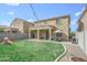 A spacious backyard features a covered patio, green lawn, patio furniture, and a playset at 6749 W Charter Oak Rd, Peoria, AZ 85381