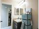 A bathroom features a dark vanity and storage next to the sink, with a doorway to the shower at 6749 W Charter Oak Rd, Peoria, AZ 85381