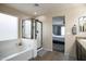 A bathroom with a bathtub, separate shower, granite countertop vanity, and doorway view into a bedroom at 6749 W Charter Oak Rd, Peoria, AZ 85381