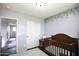 Bedroom featuring a wooden crib, closet, and floral-themed accent wall at 6749 W Charter Oak Rd, Peoria, AZ 85381