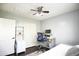 Bedroom with a modern desk, ceiling fan, and closet, with wood floors and neutral colors at 6749 W Charter Oak Rd, Peoria, AZ 85381