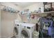 Functional laundry room with white appliances and ample storage shelves at 6749 W Charter Oak Rd, Peoria, AZ 85381