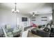 Bright living area with a modern glass table, ceiling fan, and comfortable leather seating at 6749 W Charter Oak Rd, Peoria, AZ 85381