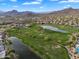 Aerial view of the lush golf course surrounded by mountains, lakes, houses and natural beauty at 7354 E Norwood St, Mesa, AZ 85207