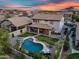 Beautiful backyard oasis with a sparkling pool, covered patio, lush lawn, and mature trees under a colorful sky at 7354 E Norwood St, Mesa, AZ 85207