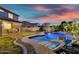 Relaxing backyard features a pool with rock waterfall, a covered patio, and lounge chairs at 7354 E Norwood St, Mesa, AZ 85207