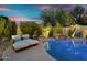 An immaculate backyard featuring a pool and lounge seating surrounded by lush landscaping at 7354 E Norwood St, Mesa, AZ 85207
