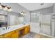 This bathroom features a double sink, bathtub, shower, and glass block window at 7354 E Norwood St, Mesa, AZ 85207