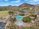 Aerial view of a community pool area featuring a pool, spa, seating, and lush desert landscaping at 7354 E Norwood St, Mesa, AZ 85207