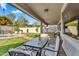 Relaxing covered patio with cushioned seating, ceiling fan, and views of the lush backyard and sparkling pool at 7354 E Norwood St, Mesa, AZ 85207