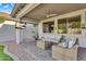 Covered patio with wicker seating, ceiling fan and an outdoor television at 7354 E Norwood St, Mesa, AZ 85207