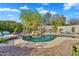 Backyard pool with a waterfall feature, lounge chairs and desert landscaping at 7354 E Norwood St, Mesa, AZ 85207