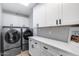 Laundry room with a washer, dryer, white cabinets, quartz counters, and ample storage space at 7820 N 5Th Ave, Phoenix, AZ 85021