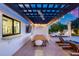 Charming outdoor dining area featuring a long wooden table, modern chairs, pergola with fan, and inviting atmosphere at 7820 N 5Th Ave, Phoenix, AZ 85021