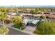 Wide aerial view showcases the house with green lawns, a modern garage door and neighborhood charm at 8229 E Devonshire Ave, Scottsdale, AZ 85251