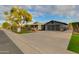 Attractive home with a well-manicured lawn, mature tree, and an extended driveway at 8229 E Devonshire Ave, Scottsdale, AZ 85251