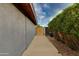 Side walkway featuring privacy gate, concrete path, and mature landscaping alongside the home at 8229 E Devonshire Ave, Scottsdale, AZ 85251