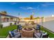 The backyard features a fire pit, seating, artificial grass, and a pool at 8431 E Rose Ln, Scottsdale, AZ 85250