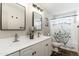 Bright bathroom with a double sink vanity, stylish mirrors, and a decorative shower curtain at 8431 E Rose Ln, Scottsdale, AZ 85250