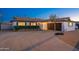A white home with a black roof featuring a long driveway with a basketball hoop at 8431 E Rose Ln, Scottsdale, AZ 85250