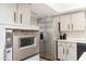 A bright kitchen with stainless steel appliances and sleek grey cabinets offers a contemporary design at 8431 E Rose Ln, Scottsdale, AZ 85250