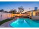 Sparkling pool with sun shelf, lush landscaping, and ample deck space at 8431 E Rose Ln, Scottsdale, AZ 85250