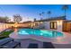 Inviting backyard pool with lounge chairs, fire pit, and privacy fence, perfect for evening relaxation at 8431 E Rose Ln, Scottsdale, AZ 85250