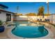 Enjoy outdoor relaxation at this inground pool with patio furniture, palm trees and manicured backyard at 8431 E Rose Ln, Scottsdale, AZ 85250