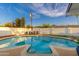 Inviting in-ground pool with lounge chairs for relaxation, set against a backdrop of mature trees and blue skies at 8431 E Rose Ln, Scottsdale, AZ 85250