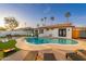 Backyard swimming pool with lounge chairs, a fire pit, and corn hole at 8431 E Rose Ln, Scottsdale, AZ 85250