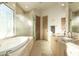 Spa-like bathroom with double vanities, a soaking tub, a walk-in shower, and natural light at 10040 E Happy Valley Rd # 2022, Scottsdale, AZ 85255