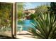 Backyard pool framed by vibrant greenery, viewed through a window, offering a glimpse of the outdoor oasis at 10040 E Happy Valley Rd # 2022, Scottsdale, AZ 85255