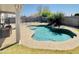 Backyard pool with safety fence, rock waterfall feature, mature palms and exterior patio at 1005 W 19Th Ave, Apache Junction, AZ 85120