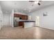 Open kitchen with an island, stainless steel appliances, and seamless flow to the living area at 1123 E Buckingham Ave, Gilbert, AZ 85297