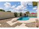 Serene backyard featuring a sparkling pool with waterfall feature and landscaped surroundings at 1237 E Gemini Dr, Tempe, AZ 85283