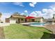 Spacious backyard featuring a pool, lush lawn, covered patio, and relaxing outdoor area at 1237 E Gemini Dr, Tempe, AZ 85283