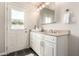 Well-lit bathroom with white vanity, granite countertop, and access to backyard at 1237 E Gemini Dr, Tempe, AZ 85283