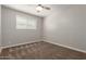 This bedroom features carpet flooring, a ceiling fan, and a window at 1237 E Gemini Dr, Tempe, AZ 85283