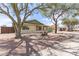 An inviting single-story home featuring desert landscaping and mature shade trees in the front yard at 1237 E Gemini Dr, Tempe, AZ 85283