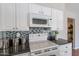 Well-lit kitchen featuring white cabinetry, granite countertops, and mosaic tile backsplash at 1237 E Gemini Dr, Tempe, AZ 85283