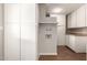 This laundry room features white cabinets, wood-look flooring, and a utility sink at 1237 E Gemini Dr, Tempe, AZ 85283