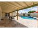 Beautiful kidney-shaped pool with a waterfall feature and covered patio seating area at 1237 E Gemini Dr, Tempe, AZ 85283