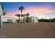 Desert landscaping, palm trees, pink sky, and modern white building at 12620 N 70Th St, Scottsdale, AZ 85254