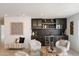Stylish bar area with dark cabinetry, wine fridge, decorative shelving, and comfortable seating at 12620 N 70Th St, Scottsdale, AZ 85254
