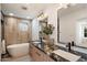 Modern bathroom featuring dual sinks with granite countertops, soaking tub, and stylish wood-look tile at 12620 N 70Th St, Scottsdale, AZ 85254