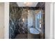 Elegant bathroom featuring a glass-enclosed shower, soaking tub, and black marble tiling at 12620 N 70Th St, Scottsdale, AZ 85254