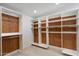 Walk-in closet with white shelving and rustic cedar plank backing for storage and organization at 12620 N 70Th St, Scottsdale, AZ 85254