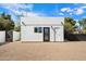 Modern exterior showing white stucco, dark trim, rock landscaping, and bright sky at 12620 N 70Th St, Scottsdale, AZ 85254