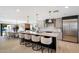 A modern kitchen is showcased with a large island, seating, stainless steel appliances and adjacent dining area at 12620 N 70Th St, Scottsdale, AZ 85254