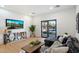 Stylish living room with a modern sofa, TV, and sliding glass doors leading to a pool area, blending indoor and outdoor living at 12620 N 70Th St, Scottsdale, AZ 85254
